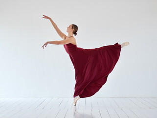 Woman, ballet and performance art in studio, learning dance and practice rehearsal in elegant dress. Person, dancer and strong girl for balance, theatre training and creative artistic movement