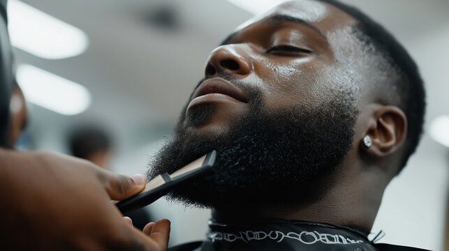 A Black man receives a precise beard trim at a barbershop, enjoying the grooming experience