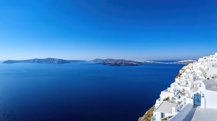 The panoramic view of Santorini white-washed buildings overlooking the deep blue Aegean Sea, Greece