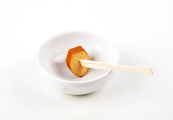 Scheibe Tofuwurst auf Holzspieß in Porzellanschale auf weißem Hintergrund