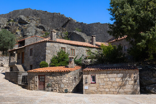 historic village of Sortelha, Portugal, featuring stone houses and ancient fortress walls under a bright blue sky. This charming medieval village is a perfect example of Portuguese cultural heritage.