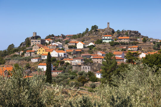 historic village of Sortelha, Portugal, featuring stone houses and ancient fortress walls under a bright blue sky. This charming medieval village is a perfect example of Portuguese cultural heritage.