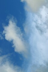 Vertical composition of cloudy sky on a blue background.