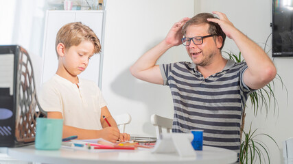 A strict father is stressed when he helps a child learn to do homework for school