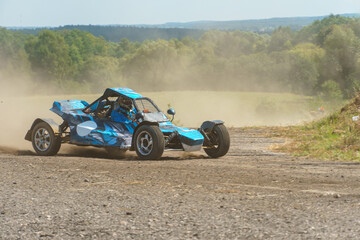 Fototapeta premium A close-up of an autocross racing car. Clouds of dust and sand burst out from under the wheels. Off-road racing.