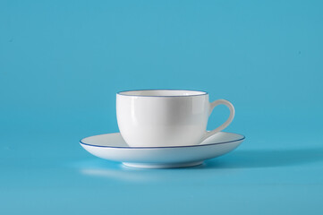 Empty cup and saucer on a blue background.