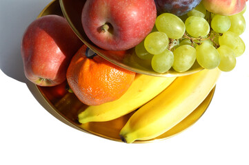Appetizing, decadent gold tiered fruit platter isolated on white background, luxury, gourmet food presentation, apple, banana, grapes, mandarine orange, fig, mango, plum, peach detailed, close up.