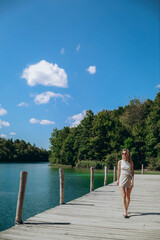 beautiful Ukrainian Caucasian girl walks gracefully across a wooden bridge at the stunning Plitvice...