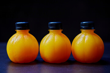 Orange juice in ​bottle on black background