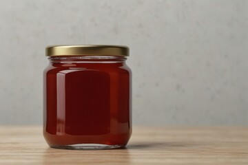 red honey jar kept on a wooden table