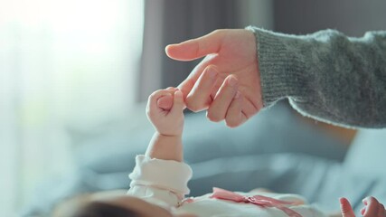 Close-up little hand of child baby holding hand of mother, A newborn holds on to mom's, dad's finger, Love and relationship with infant, Care and support, Dreaming and protection