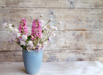 Small blue vase with beautiful summer flowers 