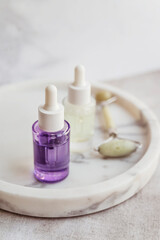 Bakuchiol serum and jade roller  in a marble plate 