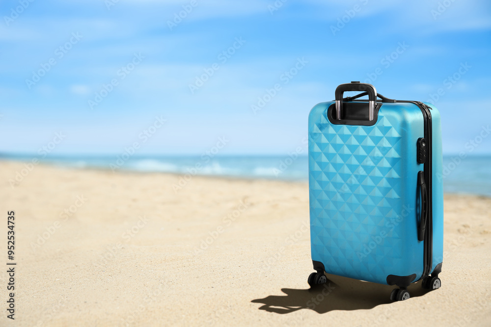 Sticker One light blue suitcase on sandy beach near sea. Space for text