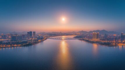 Naklejka premium A drone photo of the brightly lit blue bridge across West Lake in Hangzhou at night, with city lights and skyscrapers on both sides. The moon is shining above it, creating an enchanting atmosphere.