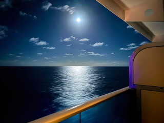 The Full moon and reflections on the ocean from a cruise ship balcony in mid ocean