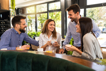 Group of friends met at the restaurant. They hang out, drink coffee and laugh.