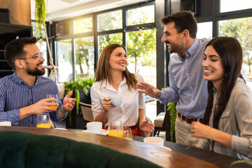 Group of friends met at the restaurant. They hang out, drink coffee and laugh.