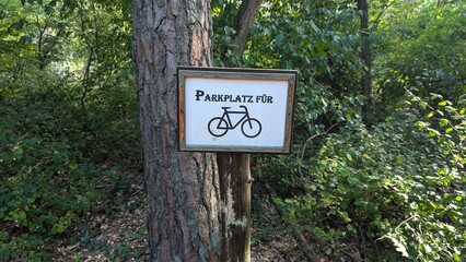 Schild mit Parkplatz f&uuml;r Fahrrad am Baum