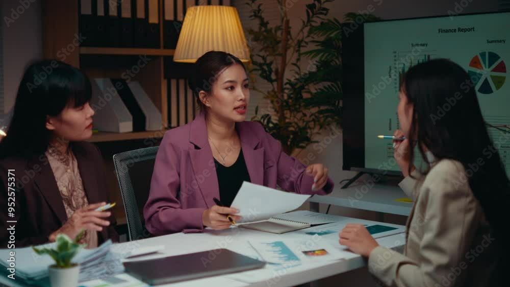 Poster three asian businesswomen are working late in the office. they are discussing a finance report and p