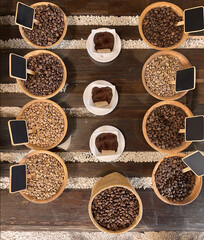 Mesa  decorada con cestas rellenas de granos de café y etiquetas negras para poner precio. 