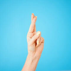 Excited, hope and model with fingers crossed isolated on blue studio background. Happy, trust and person with wish, waiting sign and hand gesture for winning or future achievement or luck emoji