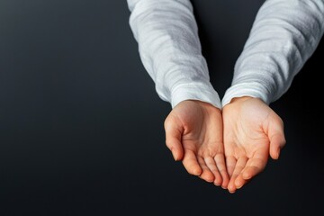 Close-up view of open hands ready to receive, symbolizing trust, generosity, and openness against a dark background.