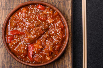Thai Asian dish with meat, hot pepper, tomato sauce and sesame