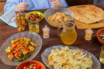 The hand of a Muslim woman at the festive table on the holiday of Kurban Bayram takes an inik.