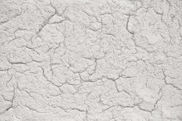Light grey clay wall with cracks, surface texture. Close up. Background for the background or graphic design with the concept of drought and death.