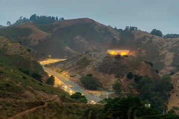 Light traffic on highway through try Marin County hills approaching tunnel