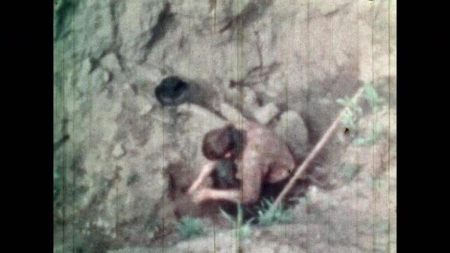 Happy treasure hunter digging ground in search of treasure, looking finding for hidden gold. Man rejoicing finding secret gold coins in mountains caves. Old archival film. Vintage archive. Retro 1960s