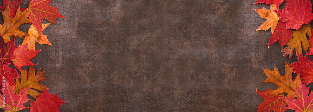 Poster colorful autumn leaves double border over a dark stone banner background. above view with copy space