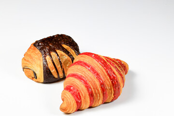 Freshly baked croissant, Chocolate Praline and Double Rasberry croissant isolated on white background. French pastry closeup photo. Buttered bread croissant.