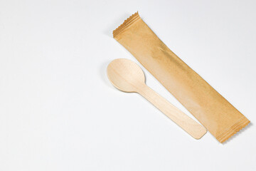 Wooden spoon, disposable tableware, Eco-friendly materials spoon with paper package isolated on white background. 