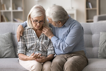 Older husband comforting frustrated beloved woman. Sad mature wife grappling with health issues or...