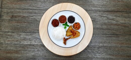 Ayam ungkep bumbu kuning or boiled chicken with curry seasoning and coconut water. Served with varian sambal or hot chili sauce. Ready to fried
