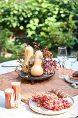 Fall table setting with pumpkins and leaves and hydrangea in brown and burgundy tones