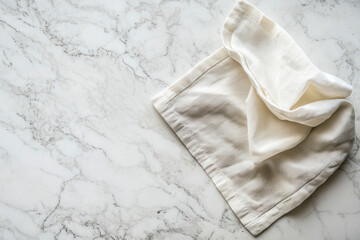 Obraz premium Overhead Shot of a White Linen Napkin on a White Marble Kitchen Counter with Room for Text.