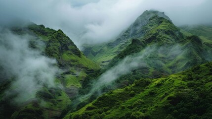 Lush green mountainsides with misty clouds overhead