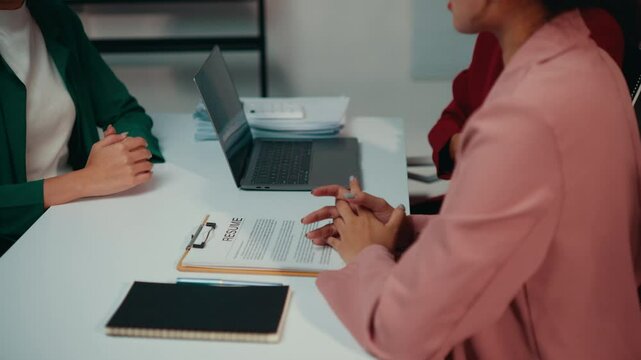 Human resources manager conducting an interview with a job candidate at a desk in an office setting. Engaging conversation focuses on qualifications and career opportunities