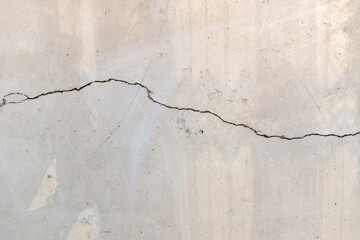 Cracked concrete wall covered with a gray cement surface as a background