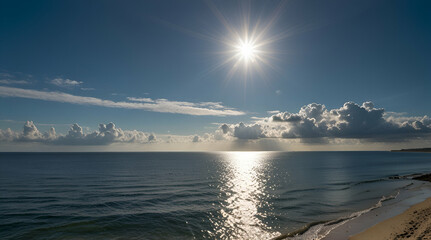 A panoramic view of blue skies and ocean with sunbeams shining above
