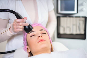 Young woman receiving treatment in cosmetology clinic. Cosmetology skin care. Aesthetic facial treatment Concept.