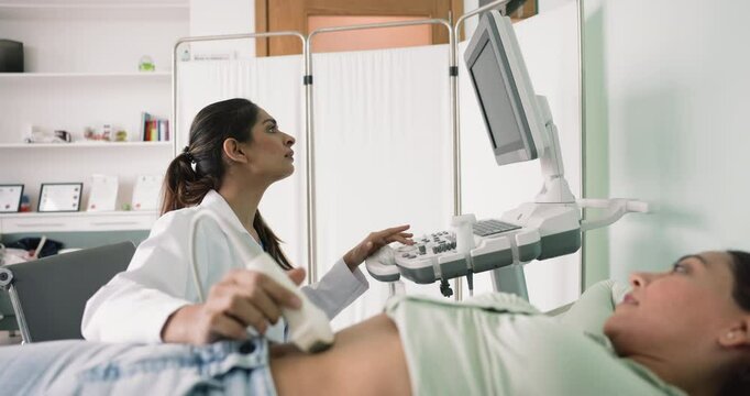 Indian female sonographer examining abdominal area of woman patient using ultrasonography equipment, perform various assessments and evaluations to prevent disease. Ultrasound examination, health-care