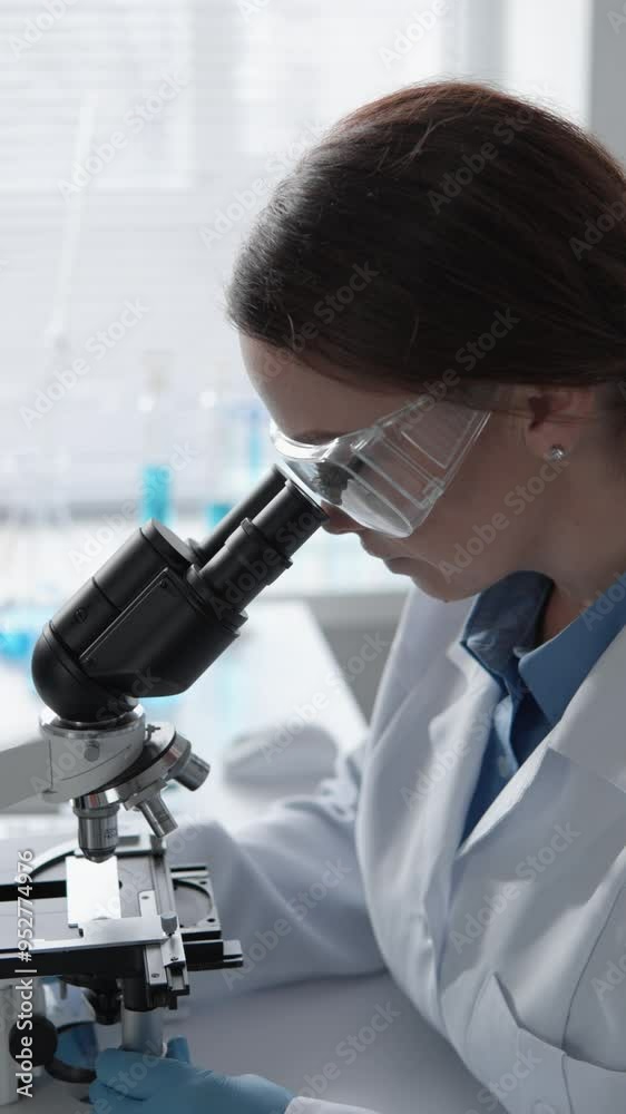 Aufkleber A scientist is conducting research with a microscope in a modern laboratory environment, focusing on analysis and experimentation in various fields such as biology, biotechnology, and chemistry