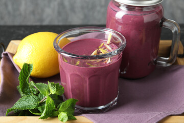 Tasty fresh acai juice with mint and lemon on table, closeup