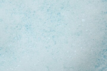Washing laundry. White foam with bubbles as background, top view