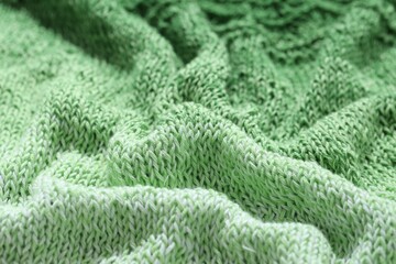 Texture of green knitted fabric as background, closeup