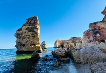 Oddly shaped jagged rock formations and cliffs at Lagoa Beach, Faro District, Southern Portugal.